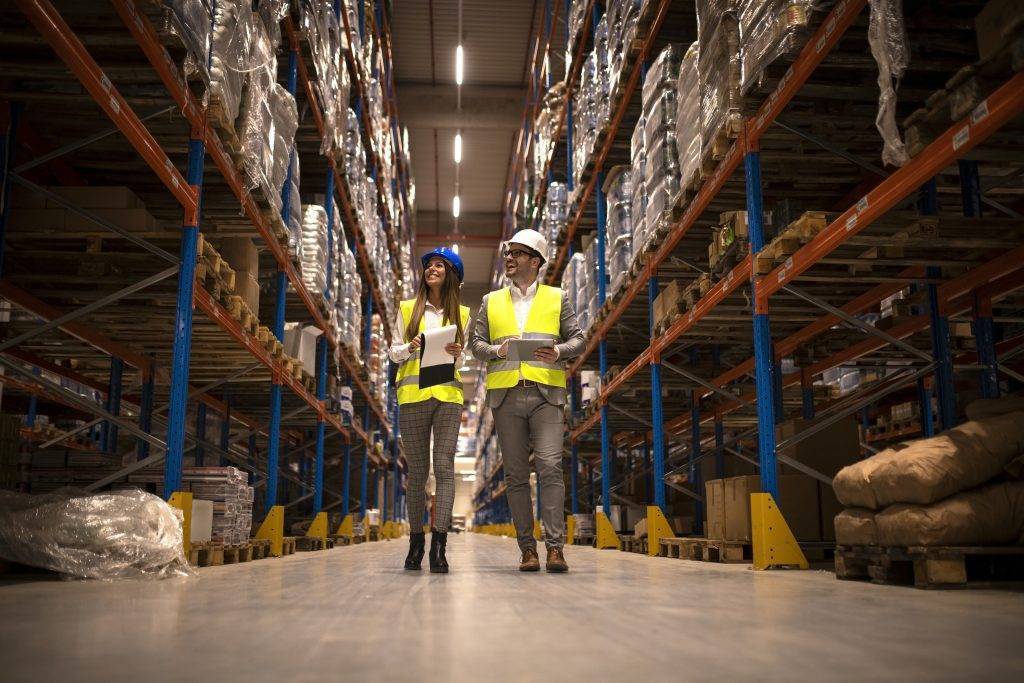 managers walking through large warehouse controlling goods distribution scaled e1663353293601