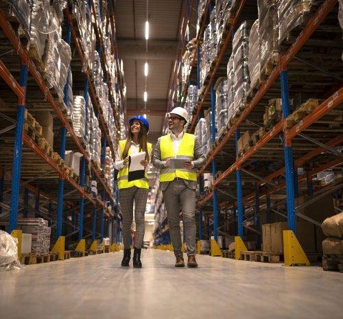managers walking through large warehouse controlling goods distribution scaled e1663353293601